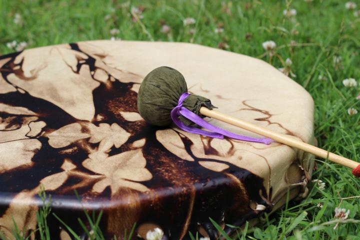 Eine schamanische Trommel liegt bei der schamanischen Einzelarbeit im Gras